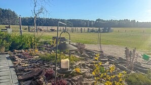 A garden area with a stone pathway, a candle, and a metal lamp post. - Lovely apartment in Szlachta with WiFi (Szlachta)
