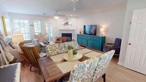 Una sala de estar amplia con comedor, chimenea y televisor.
