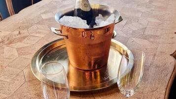 Ett kopparbadkar fyllt med is, två glas och ett bricka på ett träbord.