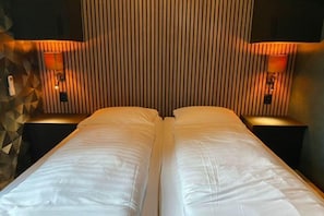 A double bed with white linens in a hotel room. - Romantic Getaway at Drenthe Nature Lodge (Dalerveen)