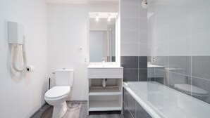 Et moderne badeværelse med toilet, håndvask og badekar.