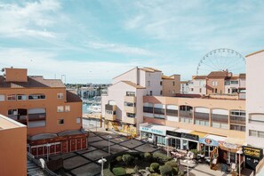 Eine Küstenstadt mit Riesenrad, Gebäuden am Wasser und einem Sushi-Restaurant.