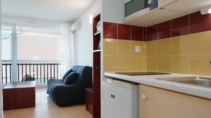 A compact kitchen with a refrigerator, a sink, and a window overlooking a balcony. - Lush corner near the local bistro (Agde)