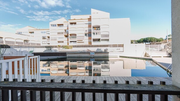 Un edificio moderno con varios balcones y una zona de piscina.
