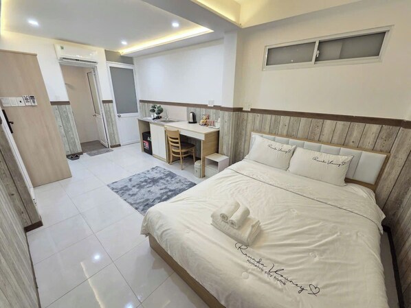 A hotel room with a bed, a desk, and a chair. - 1001 Stars (Ho Chi Minh City)
