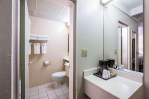 Casa de banho com sanita, lavatório e suporte para toalhas.