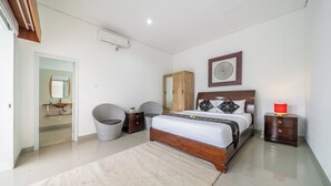 A bedroom with a bed, nightstands, a wooden wardrobe, a mirror, and a red lamp. - Q LE Villas (Seminyak)