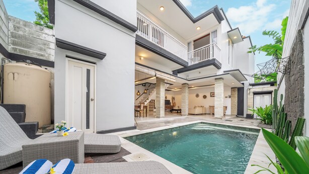 A modern house with a swimming pool, outdoor seating, and a balcony. - Q LE Villas (Seminyak)