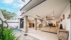 A modern living area with a pool, a sofa set, and a dining area. - Q LE Villas (Seminyak)
