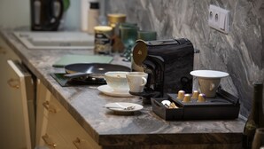 A kitchen counter with a coffee maker, cups, and a tea set. - Deluxe 1‑BR Apartment Sleeps 3– Historic Palace, Heart of Prague (Prague)