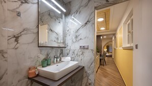 A modern bathroom with a marble sink, mirror, and wooden vanity. - Deluxe 1‑BR Apartment Sleeps 3– Historic Palace, Heart of Prague (Prague)