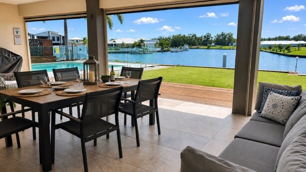 Comedor con vistas a una piscina y un lago.
