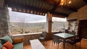 A rustic outdoor dining area with stone walls, a table, chairs, and a view of the countryside. - In Balazuc, terrace overlooking the Ardèche gorges, 300 m from the beach. (Balazuc)