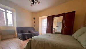 A bedroom with a bed, a sofa, a window, and a door. - In Balazuc, terrace overlooking the Ardèche gorges, 300 m from the beach. (Balazuc)