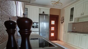A kitchen with a built-in oven, a refrigerator, and a microwave. - Gavrilis apartments: Deluxe One-Bedroom Apartment (Nenita)