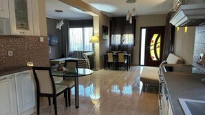 A modern hotel room with a dining area, a kitchen, and a living space. - Gavrilis apartments: Deluxe One-Bedroom Apartment (Nenita)
