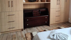 A bedroom with a large wardrobe, a TV, and a bed. - Gavrilis apartments: Deluxe One-Bedroom Apartment (Nenita)