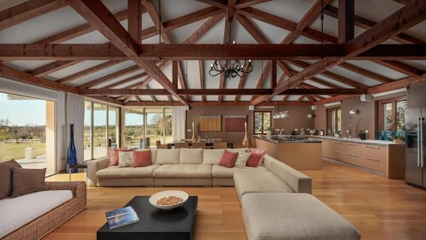 A spacious living area with a large sofa, a coffee table, and a kitchen in the background. - Malipiero Estate (Rovinj)