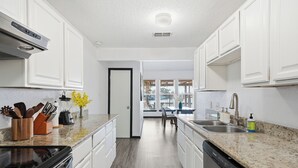 Eine moderne Küche mit weißen Schränken, Granit-Arbeitsplatten und Edelstahlgeräten.
