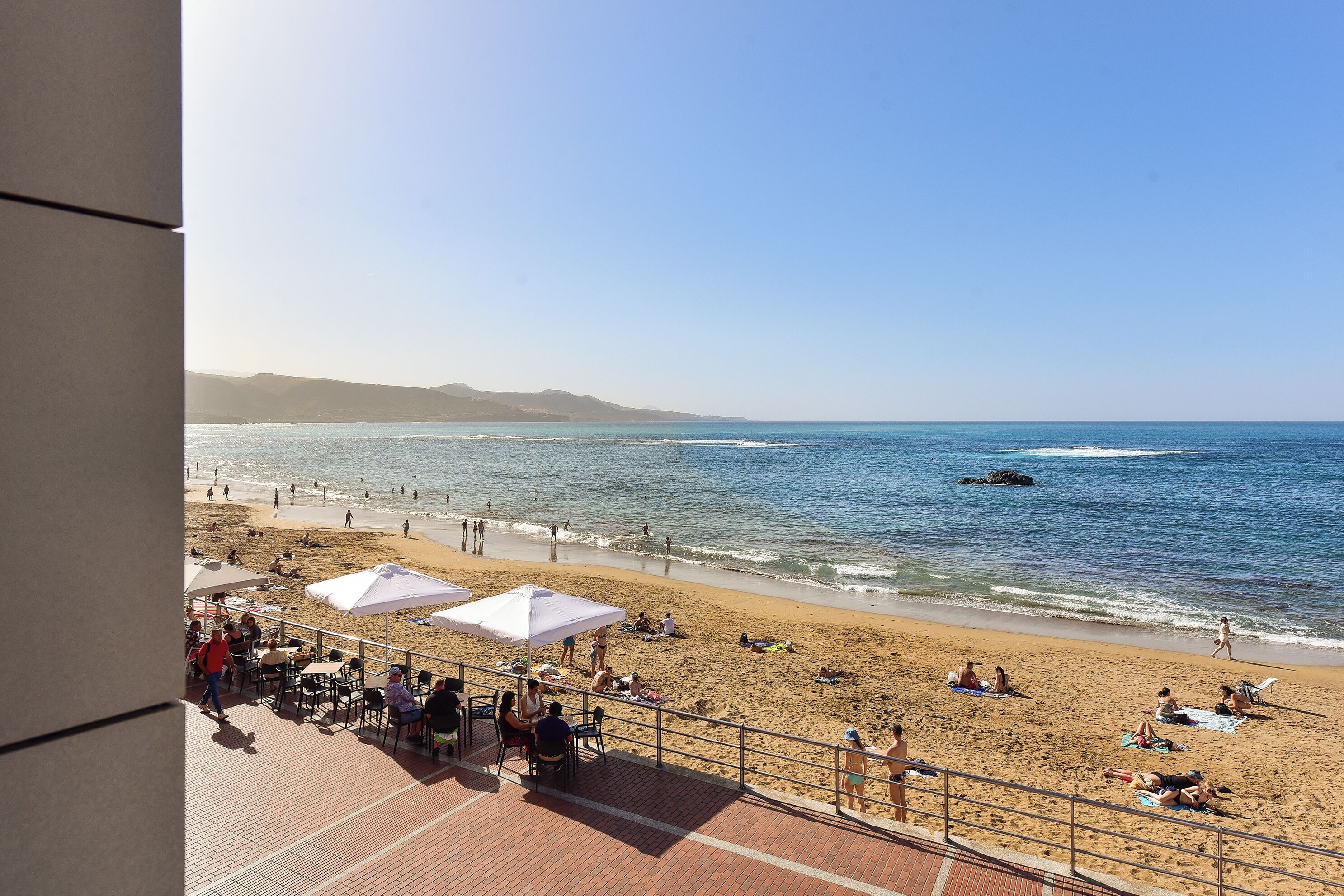 A beach with umbrellas and people.