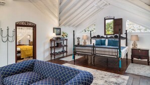 A spacious attic bedroom with a large bed, a sofa, and a chandelier. - Clingendael Weligama (Weligama)