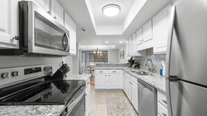 A modern kitchen with white cabinetry, stainless steel appliances, and a granite countertop. - 3BR Golf Villa Near Beach & Fairway Views (Pawleys Island)
