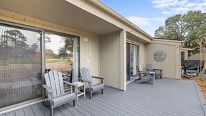 A covered deck with Adirondack chairs, a table, and a barbecue grill. - 3BR Golf Villa Near Beach & Fairway Views (Pawleys Island)