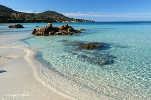 A clear beach with visible rocks and a distant mountain. - Panoramic Sea View Villa – Heated Pool (Coti-Chiavari)