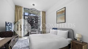 Camera d'albergo moderna con un grande letto, una scrivania e una sedia.