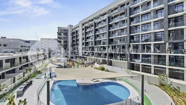 Un moderno hotel a più piani con piscina interna al cortile, balconi e un design architettonico contemporaneo.