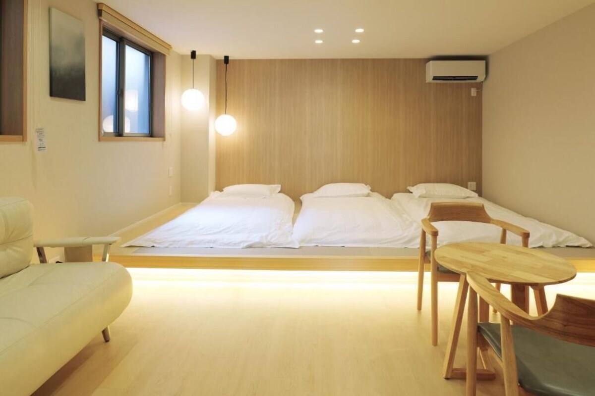 A modern hotel room with a large bed, a desk, and a chair.