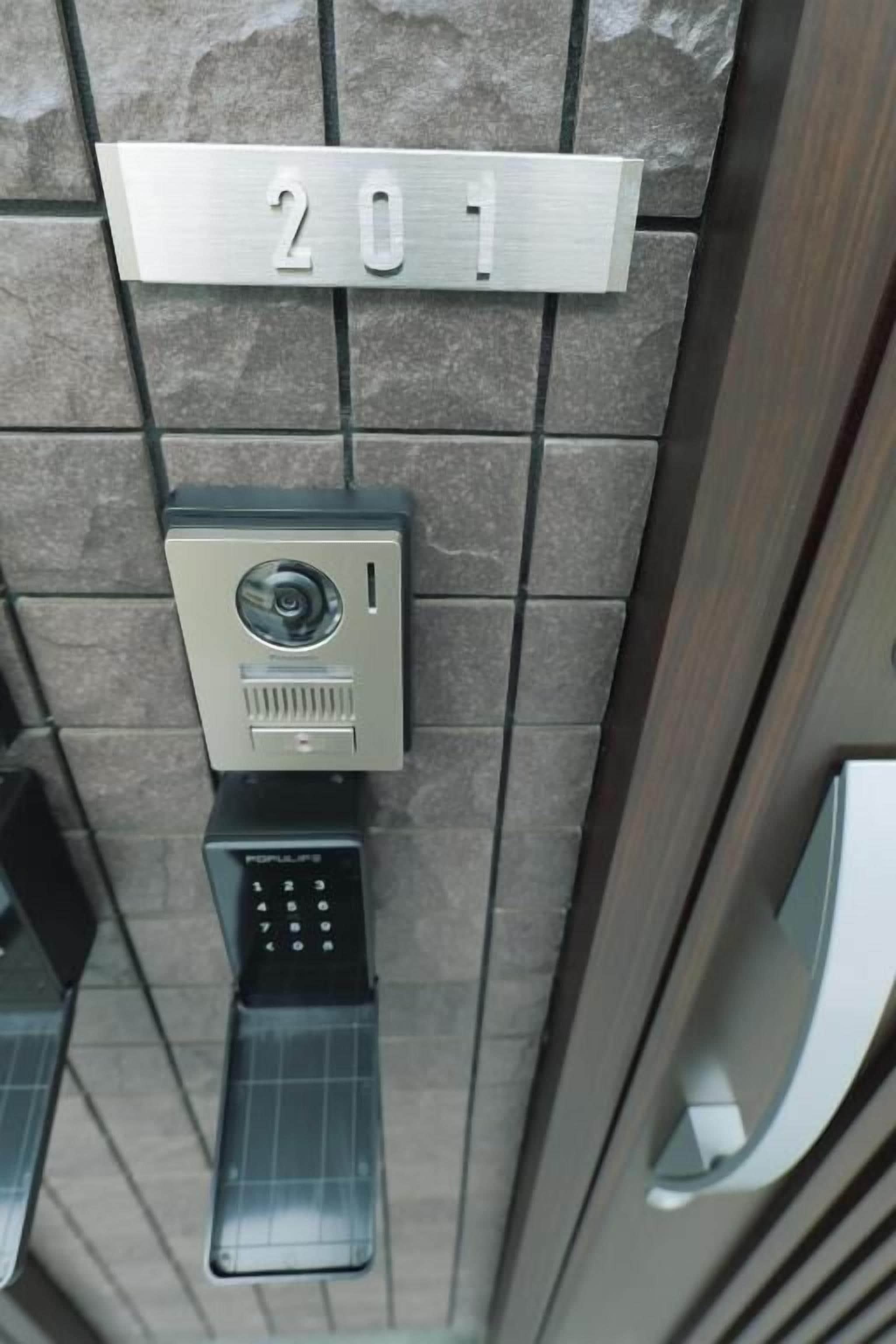 Ein Schlüsselfeld und ein Schild mit der Aufschrift '201' an einer Wand.