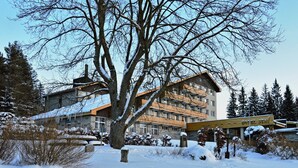 Ein Hotel mit mehreren Etagen, einer auffälligen Beschilderung und verschneiter Umgebung.