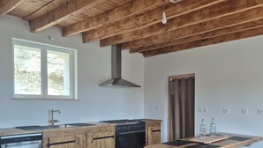Una cocina con armarios de madera, una estufa y un ventanal.