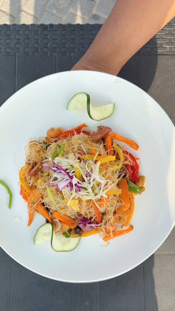 A plate of noodles with vegetables and shrimp.