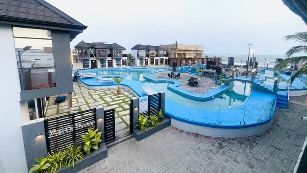 Un resort con varias piscinas, una zona cubierta y vistas al océano.