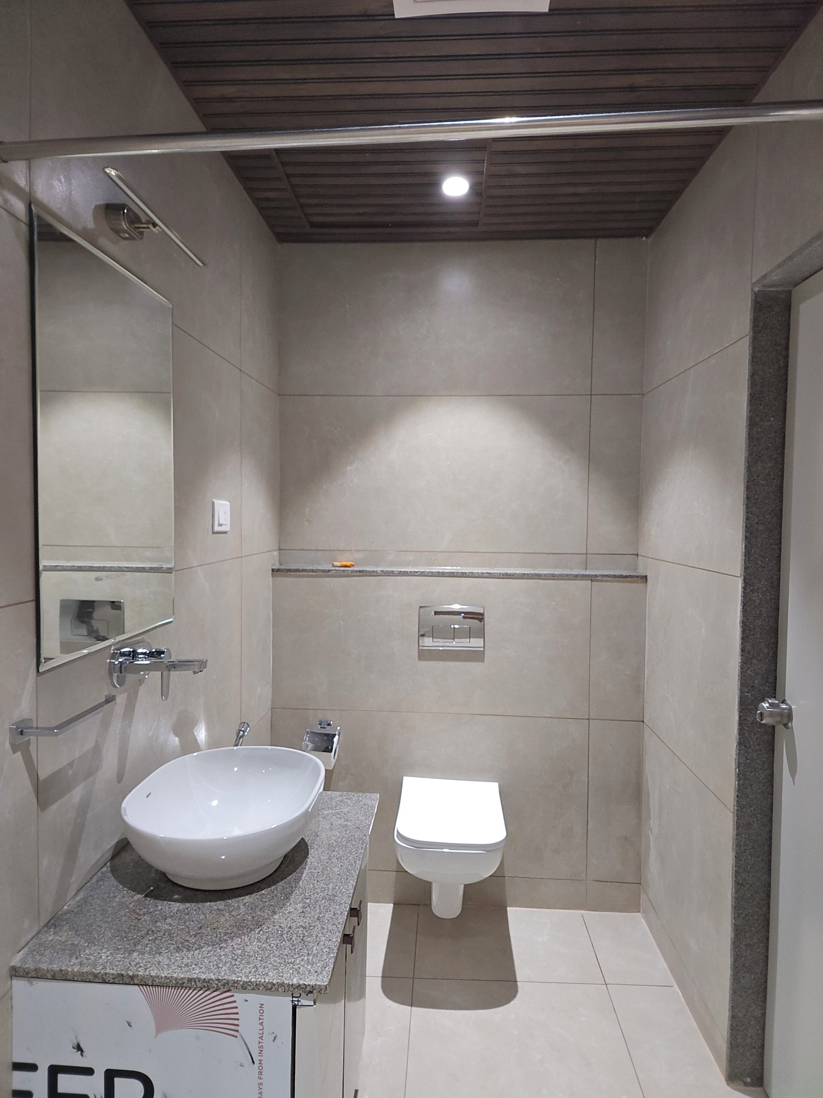 A modern bathroom with a large sink, a toilet, and a shower area.