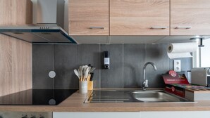A modern kitchen with a stainless steel sink, wooden cabinets, and a built-in oven. - Large, Quiet Maisonette for 10 | 24/7 Check-in (Kapfenberg)