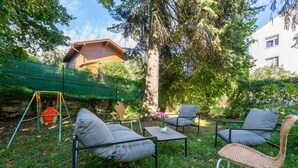 An outdoor seating area with a swing set, a table, and chairs. - Near Vienna•60m²•6 Guests• Self Check-in & Parking (Purkersdorf)