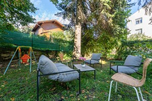 An outdoor seating area with a swing set, a table, and chairs. - Near Vienna•60m²•6 Guests• Self Check-in & Parking (Purkersdorf)