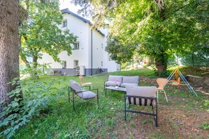 A garden area with outdoor furniture, a swing set, and a building in the background. - Near Vienna•60m²•6 Guests• Self Check-in & Parking (Purkersdorf)