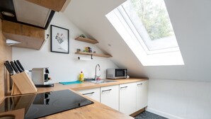 A modern kitchen with a skylight, wooden cabinets, a microwave, and a sink. - Near Vienna•60m²•6 Guests• Self Check-in & Parking (Purkersdorf)