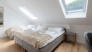 A modern bedroom with a large bed, skylights, a bedside table, and a chair. - Near Vienna•60m²•6 Guests• Self Check-in & Parking (Purkersdorf)