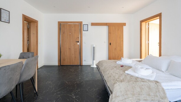 Una habitación de hotel moderna con cama, escritorio y dos puertas.