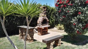 A stone outdoor kitchen with a pizza oven, a wooden bench, and a small table. - Apartment 'Pathos Retreat Mandorlo' with Shared Pool, Wi-Fi and Air Conditioning (Arenella)