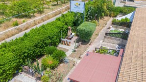 An aerial view of a property with a red roof, a paved patio area, and a signboard. - Apartment 'Pathos Retreat Ulivo' with Shared Pool, Wi-Fi and Air Conditioning (Arenella)