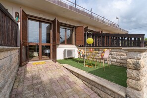 A modern house with a patio, a table with chairs, and a yellow paper lantern. - Apartment 'Pathos Retreat Lavanda' with Shared Pool, Wi-Fi and Air Conditioning (Arenella)