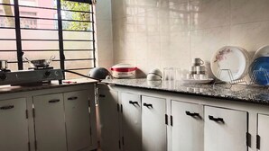 A kitchen with cabinets, a stove, and various kitchenware. - Beltola Lodge - a serene homestay (Guwahati)