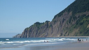 A beach with a rocky cliff and ocean waves. - Manzanita Oceanfront Inn (Manzanita)