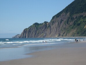 A beach with a rocky cliff and ocean waves. - Manzanita Oceanfront Inn (Manzanita)